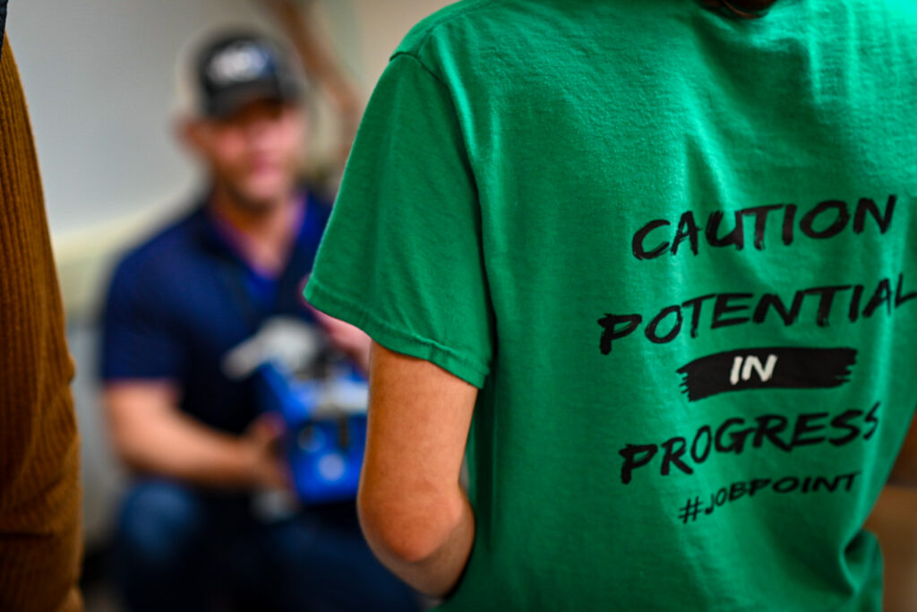 Close up shot of a student wearing a shirt that says "Caution. Potential in Progress"