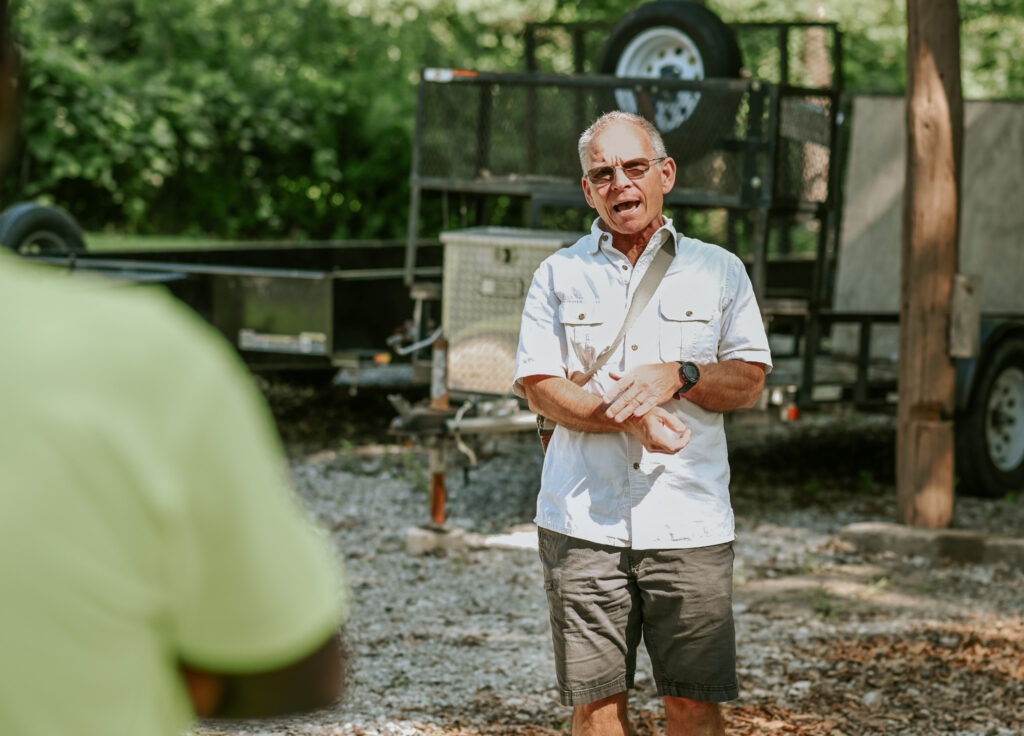 Dan Hanneken speaks, the shoulder of a listener can be seen in the foreground