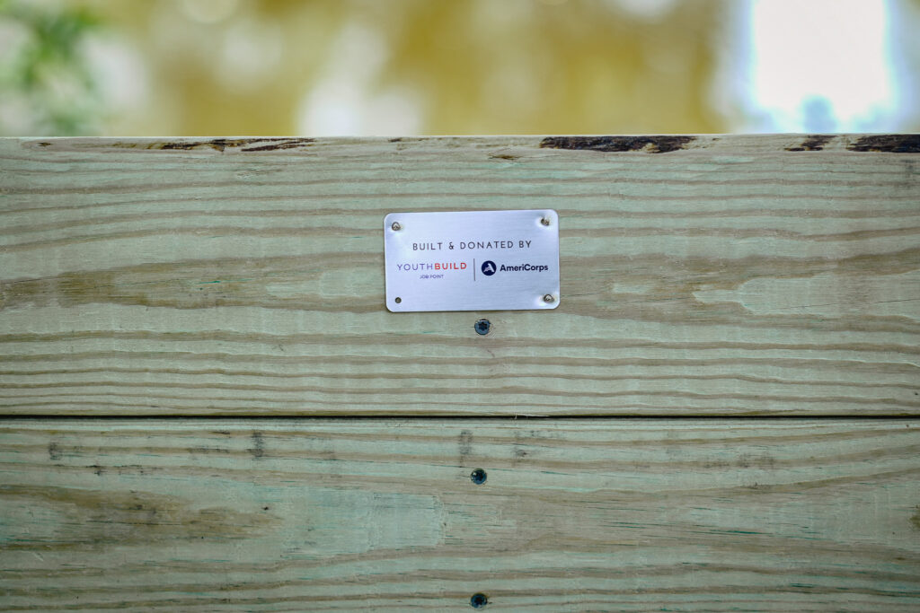 A close-up picture of a metal plaque that reads "built and donated by Job Point's YouthBuild and AmeriCorp."