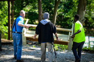 Students and residents of In2Action unload a bench together.