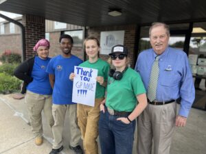 Students holding a sign that says "Thank You GP MADE" standing in front of Job Point's office.